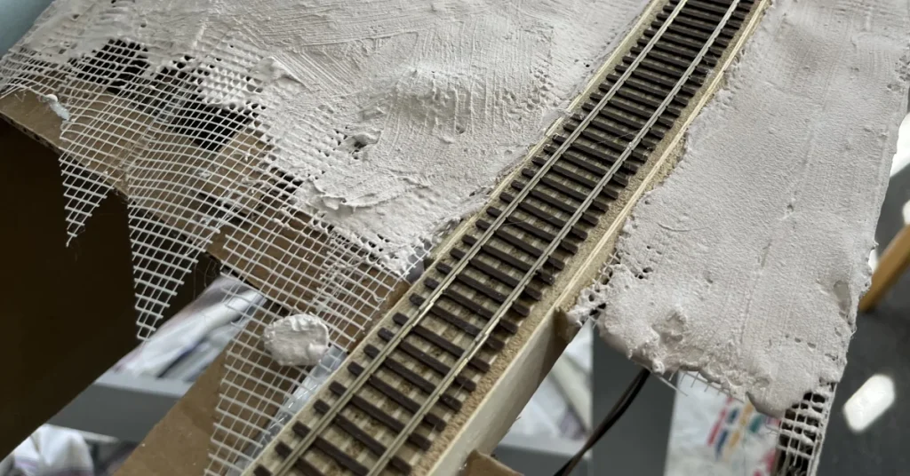 Close up look at the fiber tape installed over cardboard web forms the base of the hardshell scenery